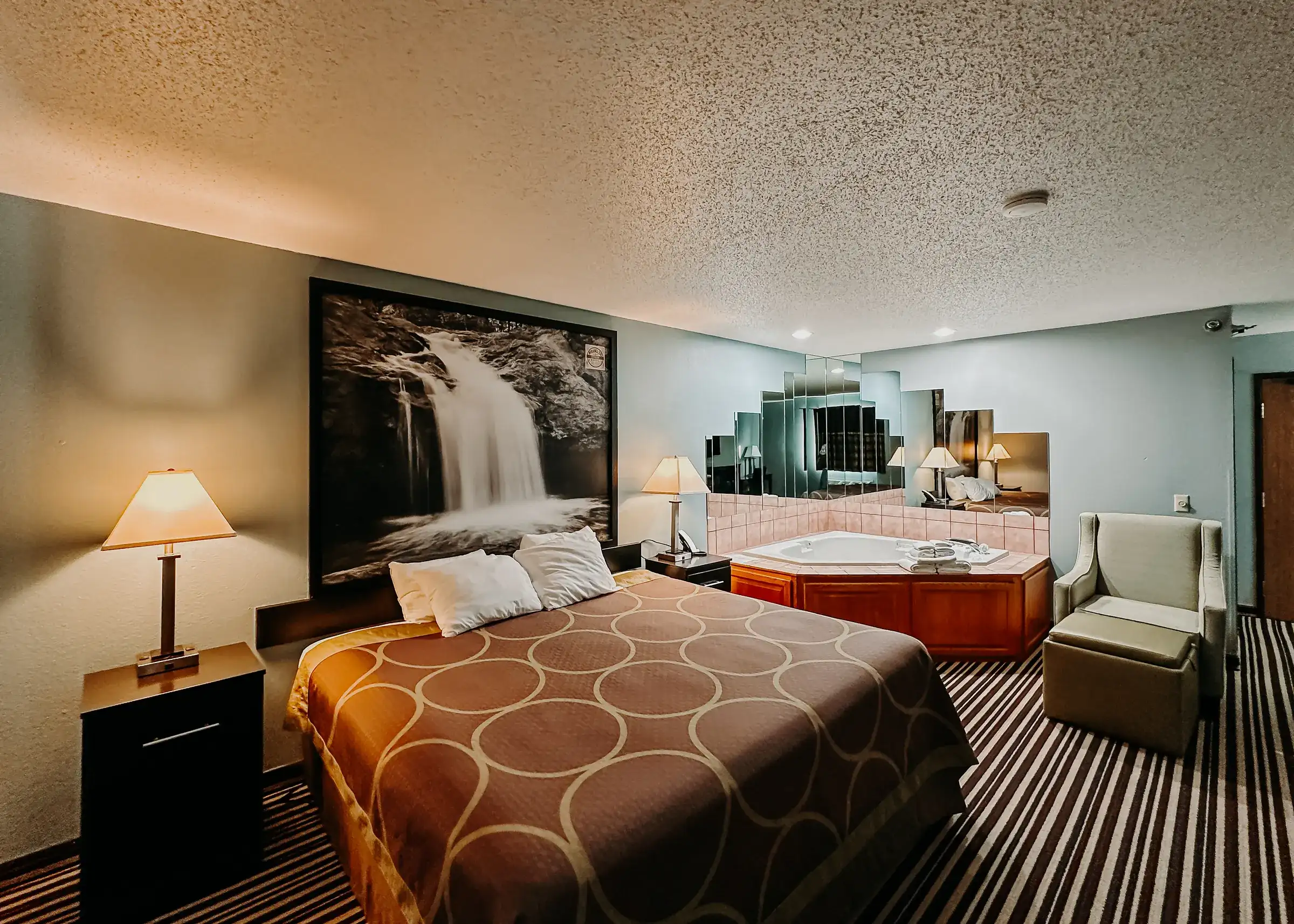 The full executive room: king bed, armchair and corner jetted tub in one open space