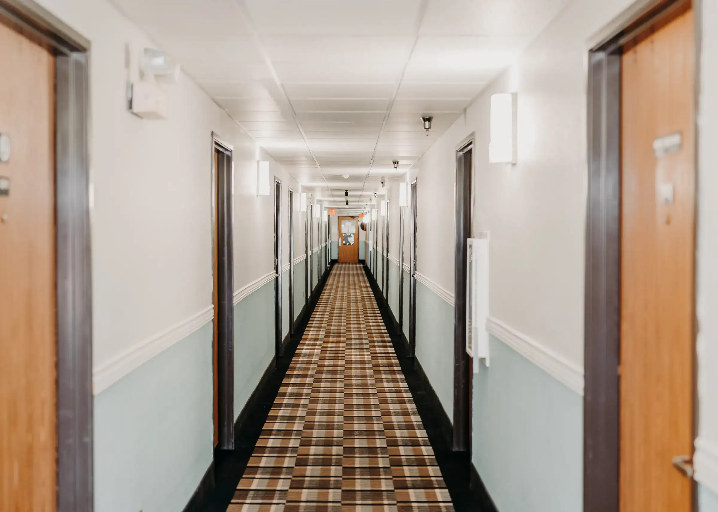 A bright interior corridor leading to the guest rooms