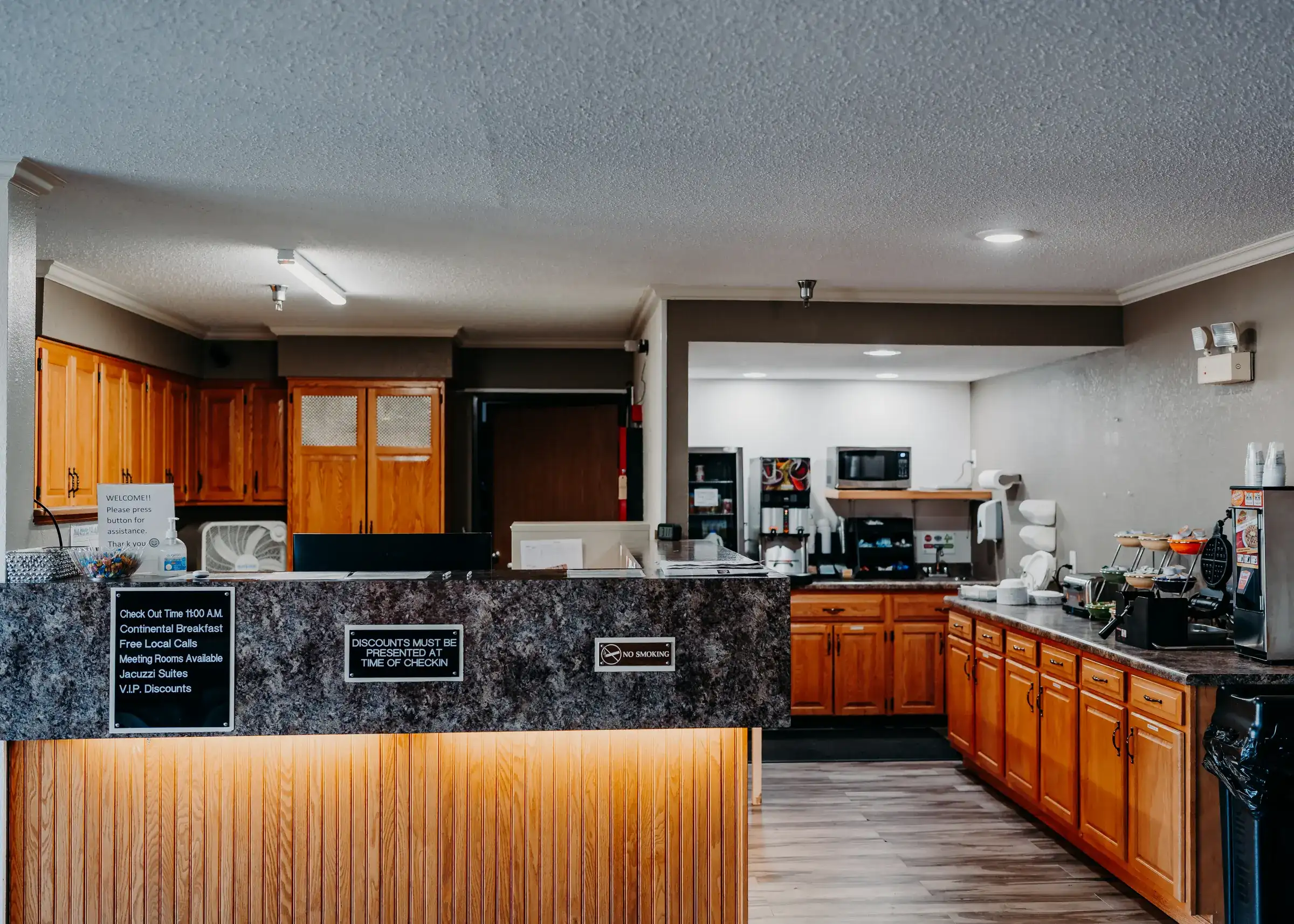 The front desk seen from the lobby, with the breakfast counter and waffle station beyond it