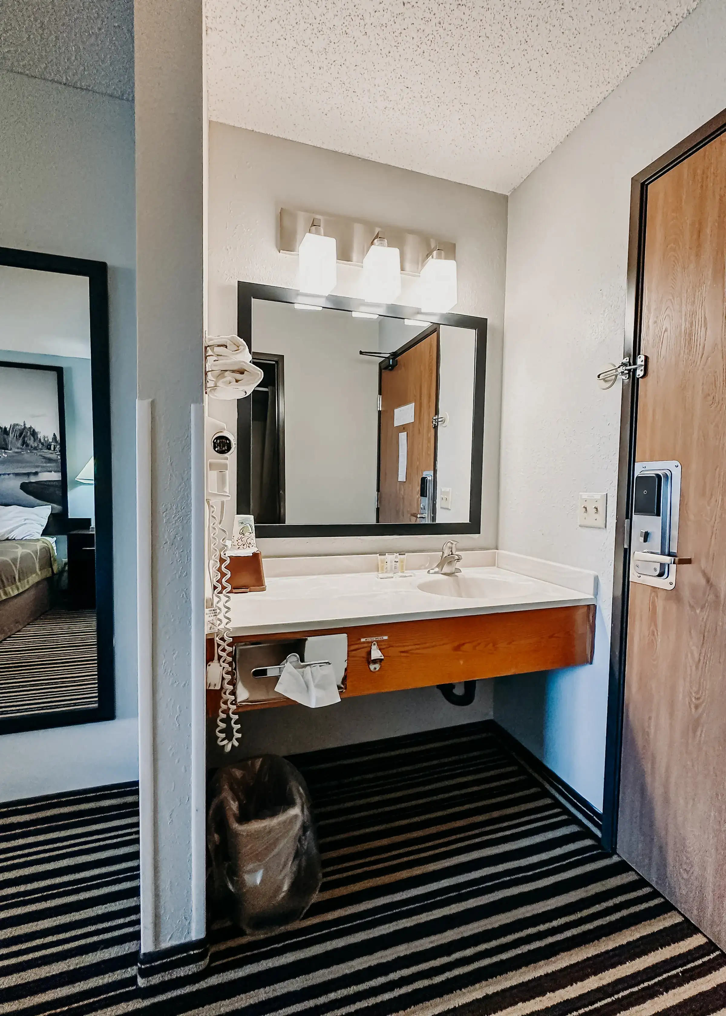 Guest bathroom vanity with a lit mirror, hair dryer and fresh towels