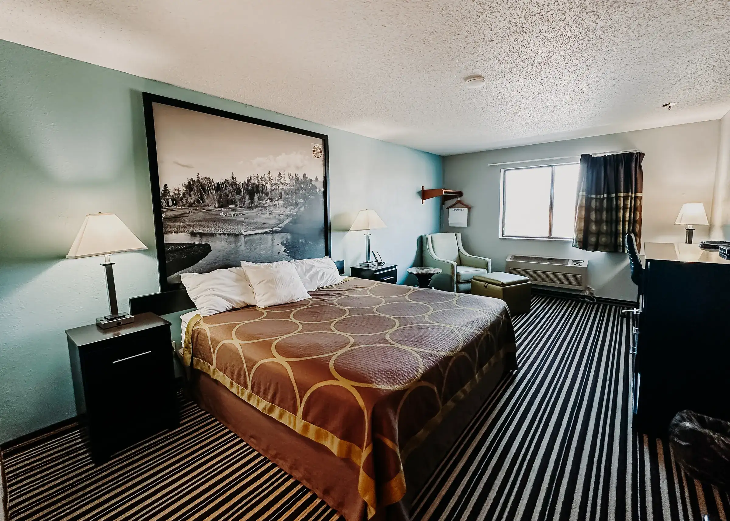 King room with an armchair by the window and a work desk